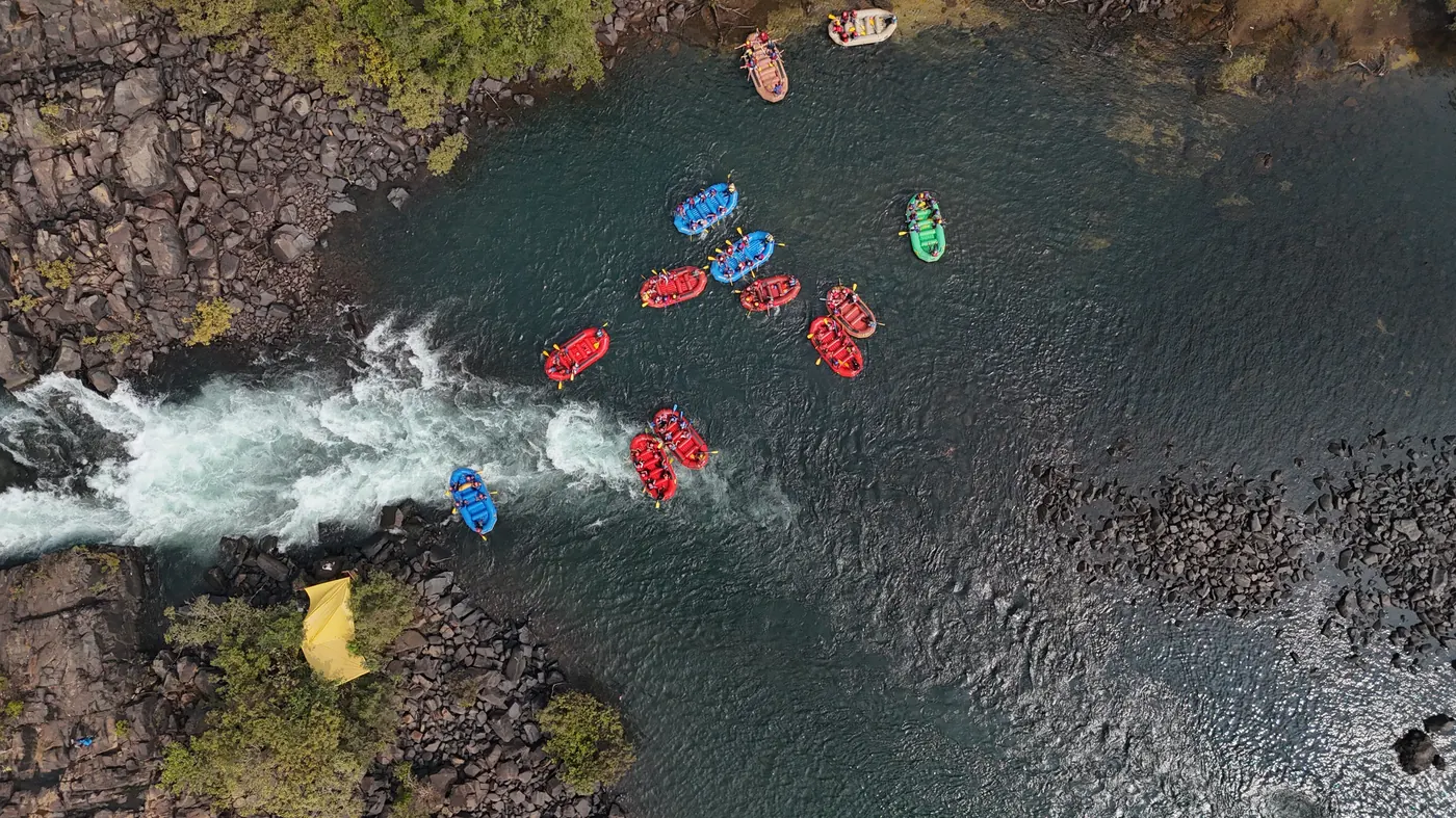 Aerial view of rafts on the Kali River surrounded by forest in Dandeli